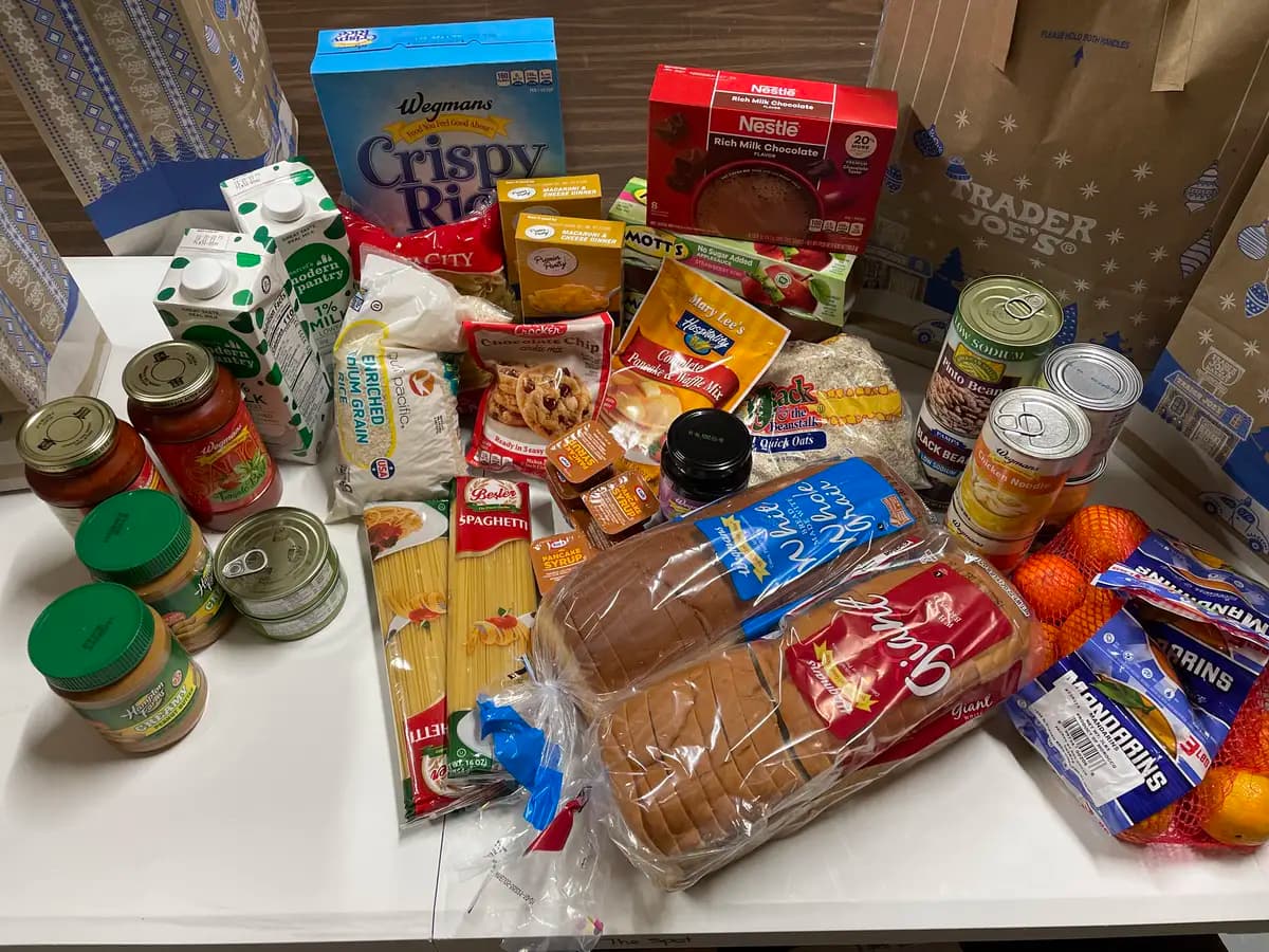 One SpotMart grocery bag's contents: cereal, milk, pasta, sauce, peanut butter, tuna, bread, and mandarins