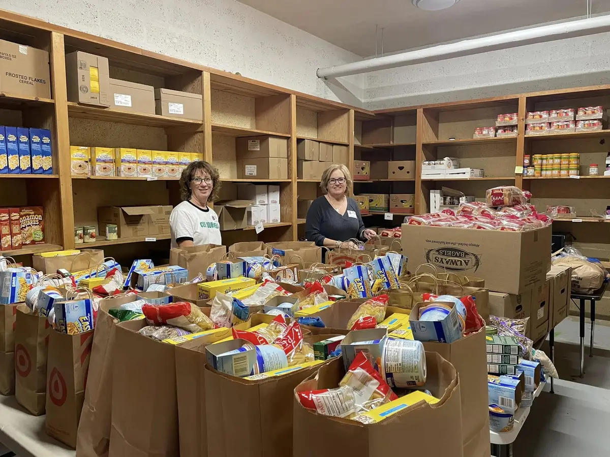 Two volunteers with packed grocery bags in the SpotMart pantry