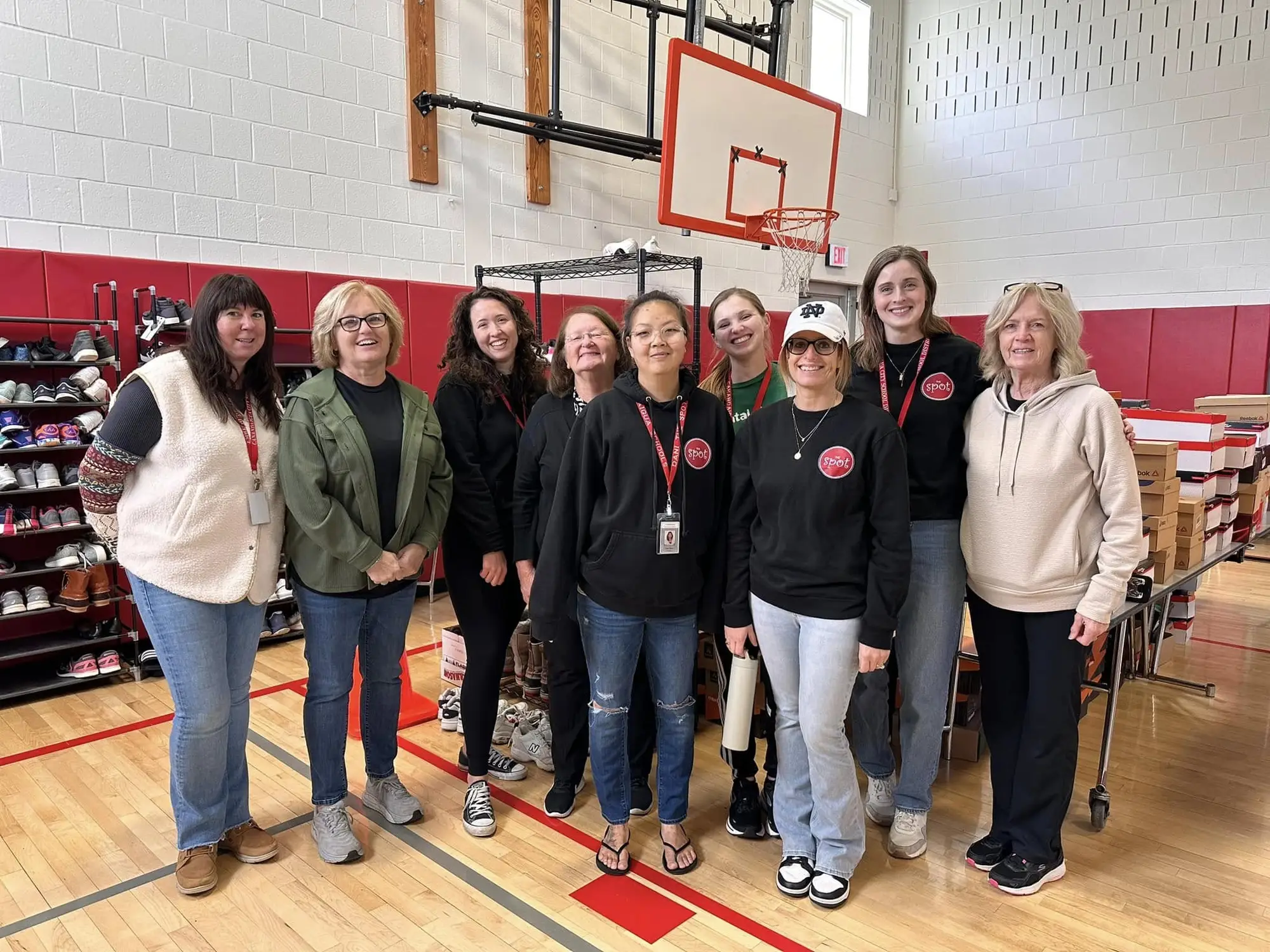 The Spot volunteers in a school gym set up for a free clothing and shoe event